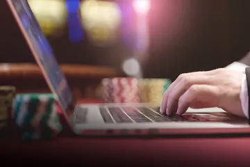 A professional dealer in a tuxedo greeting players at the roulette table, symbolizing the authentic live casino feel at VS999.